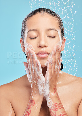 Buy stock photo Shot of a beautiful young woman enjoying a shower against a blue background