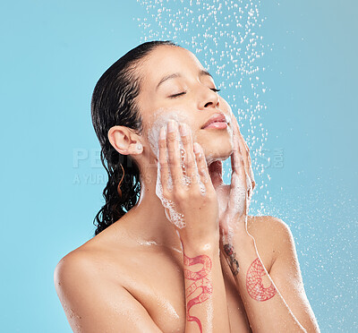 Buy stock photo Shot of a beautiful young woman enjoying a shower against a blue background