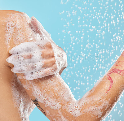 Buy stock photo Shot of an unrecognizable woman enjoying a shower against a blue background