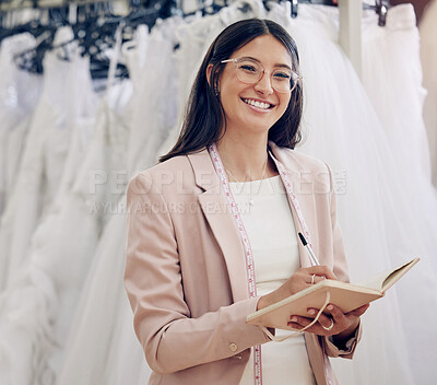 Buy stock photo Shot of an attractive young seamstress writing notes while working in her boutique