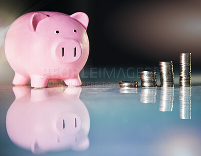 Buy stock photo Shot of a piggybank and stacked coins on a desk in an empty office
