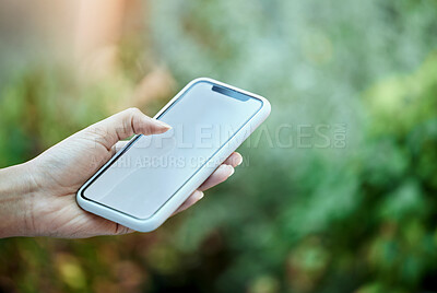 Buy stock photo Mockup, mobile phone and hand of person in park for social media, online communication or browsing internet. Bokeh, scrolling and closeup of woman on smartphone for promotion, copy space or branding