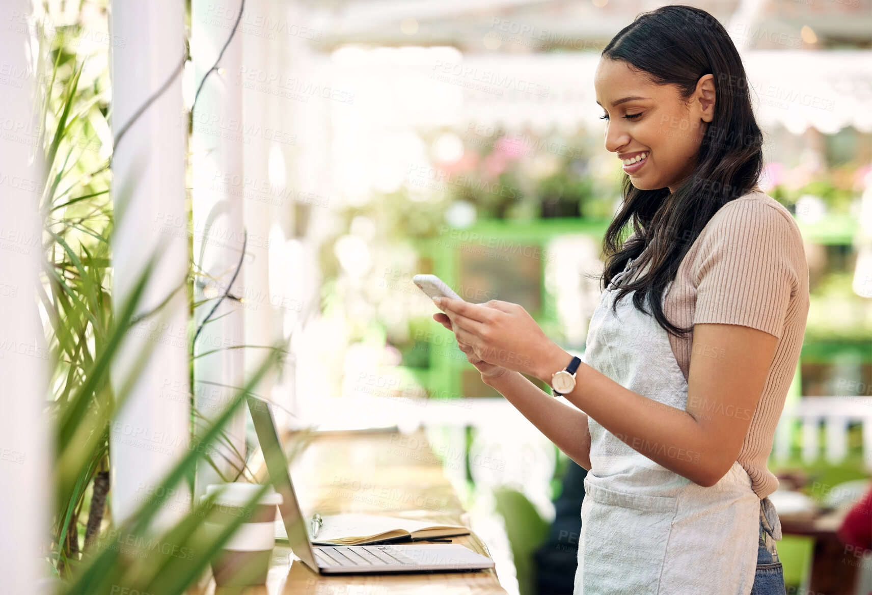Buy stock photo Happy, planning and a woman with a phone at a nursery for orders, business app or stock email. Smile, contact and a young florist with a mobile for social media, work management and connection