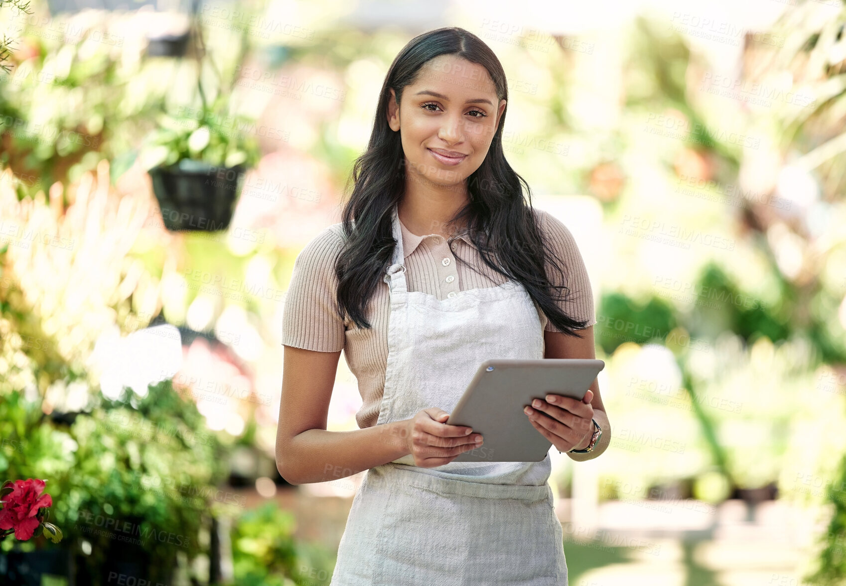 Buy stock photo Shot of a nursery owner using her digital tablet