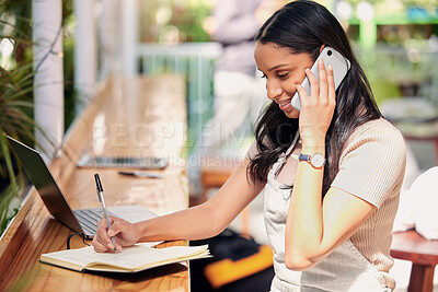 Buy stock photo Shot of a young florist using her smartphone to make a call while using a laptop and making notes