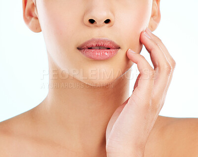 Buy stock photo Beauty, natural and mouth of woman in studio on blue background for cosmetics or dermatology. Face, hand and skincare with model touching cheek at spa for collagen, health or wellness treatment