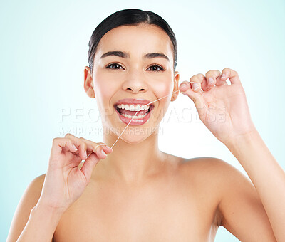 Buy stock photo Portrait, floss and woman in studio, dental and cleaning of teeth for oral health, routine and smile. Blue background, hygiene and washing of tooth, maintenance and happy for gums and treatment