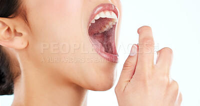 Buy stock photo Cropped shot of an unrecognizable young woman using breath freshener against a light background
