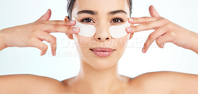 Buy stock photo Studio portrait of an attractive young woman using under eye patches against a light background