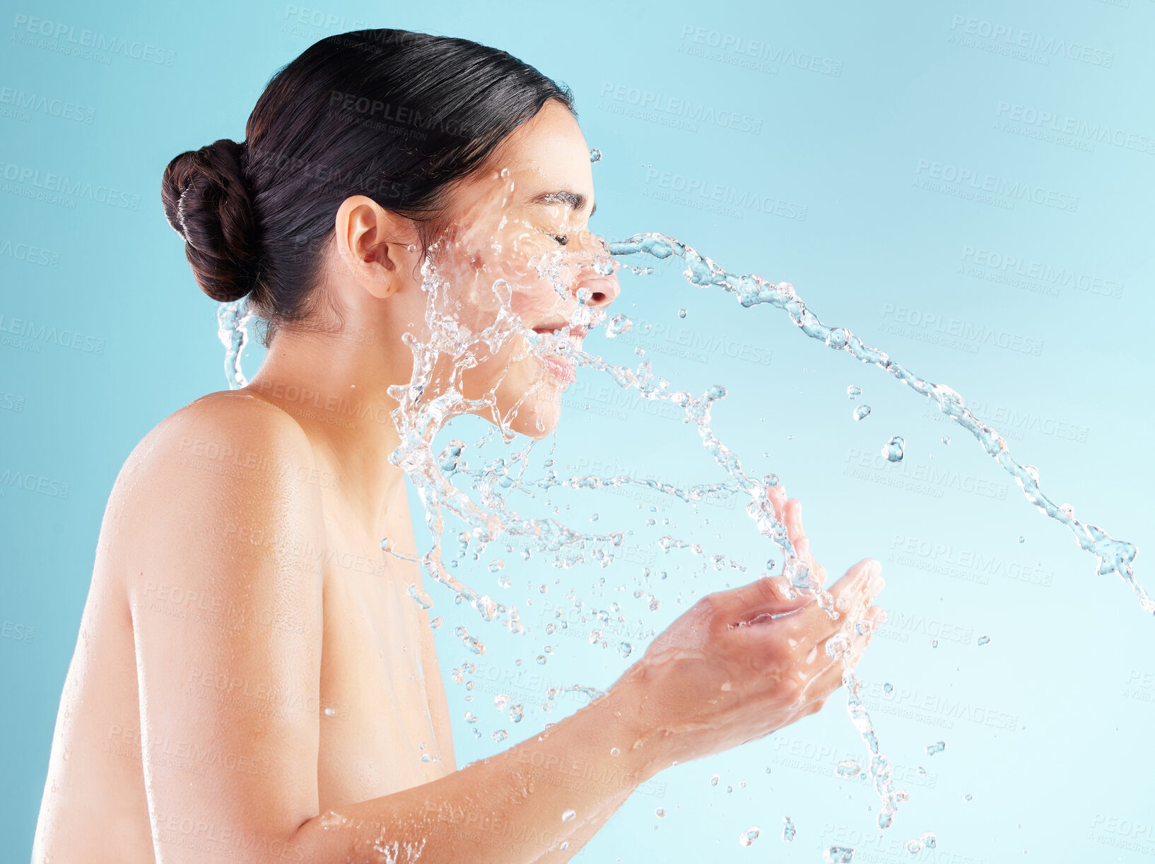 Buy stock photo Studio, happy and woman with water splash in face for natural hygiene, routine or morning skincare. Hand, profile and female person with liquid for dermatology, health and wellness on blue background