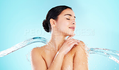 Buy stock photo Cleaning, hydration and water splash with woman in studio on blue background for skincare. Beauty, hygiene and wellness with satisfied or wet model in spa shower for calm, relaxation and washing