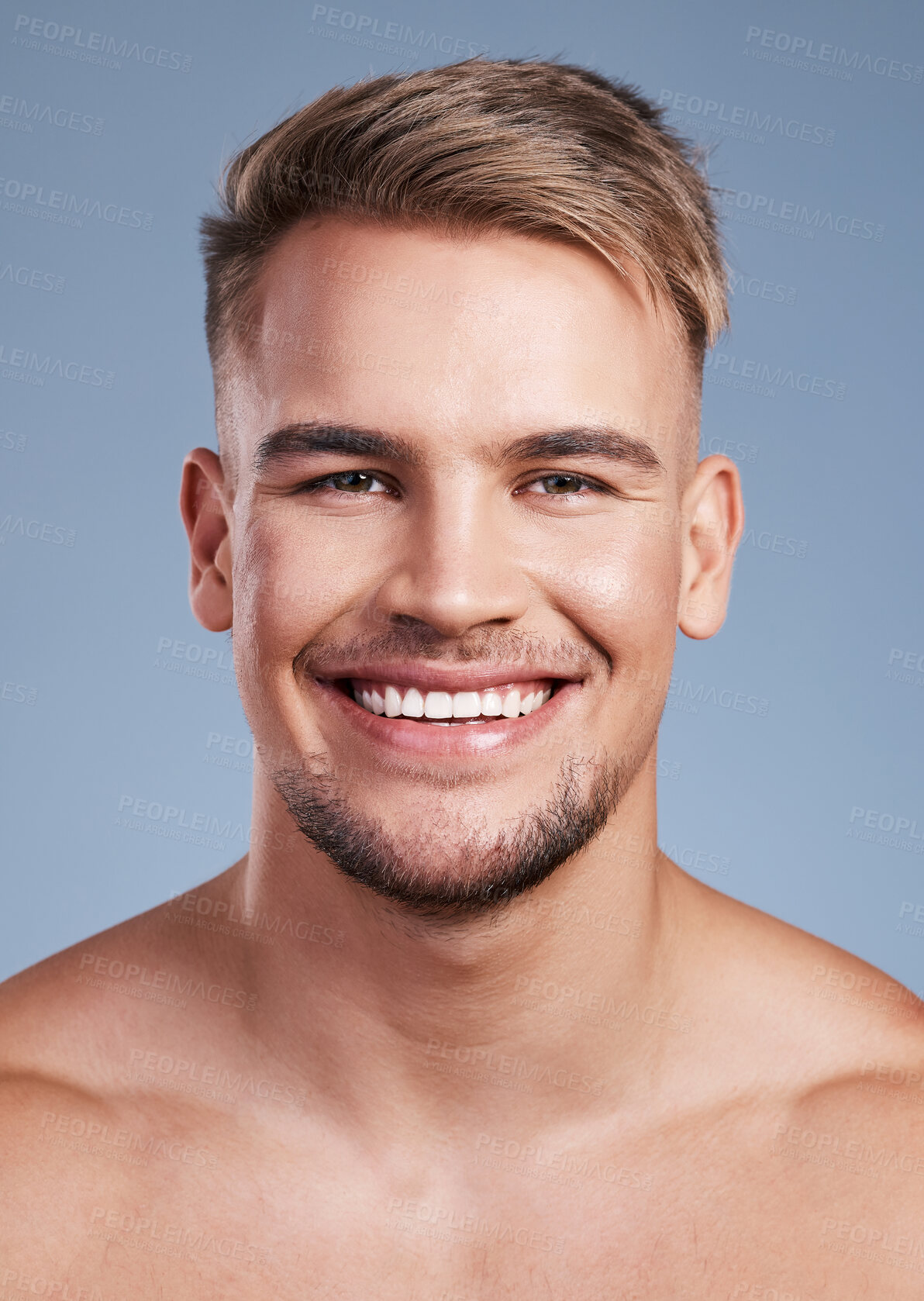 Buy stock photo Closeup shot of a handsome young man smiling while posing against a studio background