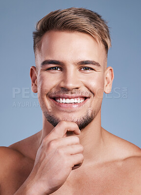 Buy stock photo Closeup shot of a handsome young man smiling while posing against a studio background