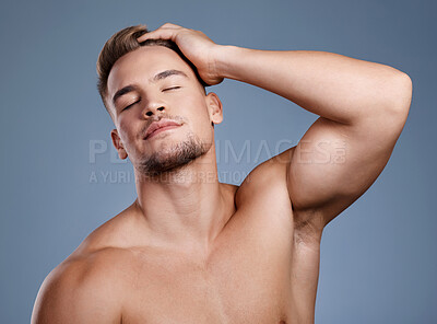 Buy stock photo Studio shot of a handsome young man posing against a grey background