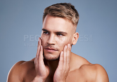 Buy stock photo Studio shot of a handsome young man posing against a grey background