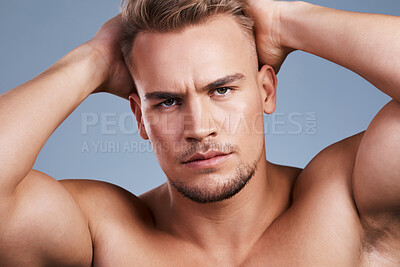 Buy stock photo Studio shot of a handsome young man posing against a grey background