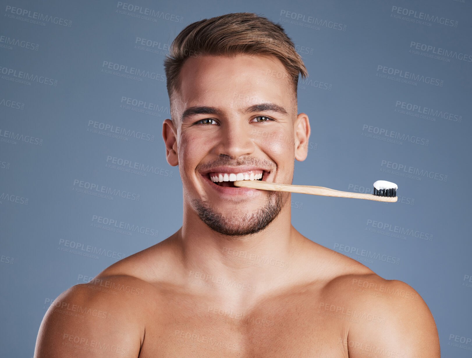 Buy stock photo Shot of a handsome young man posing with a toothbrush in his mouth