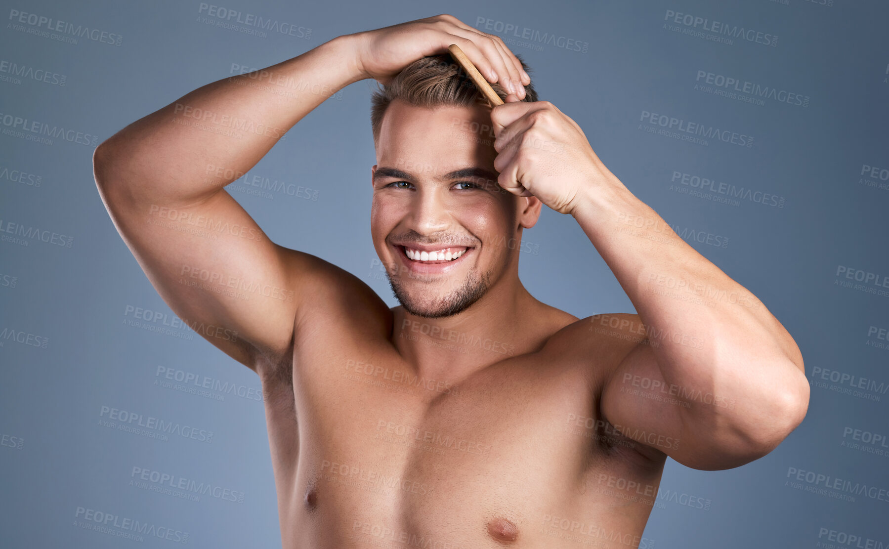 Buy stock photo Shot of a handsome young man combing his hair