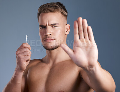 Buy stock photo Shot of a man showing the stop gesture while holding a earbud