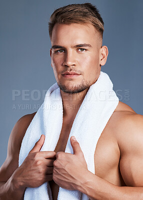 Buy stock photo Shot of a handsome young man posing with a towel around his neck