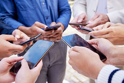 Buy stock photo Closeup shot of a group of businesspeople using their cellphones in synchronicity outside