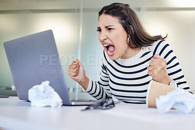 Buy stock photo Shot of a young businesswoman looking angry while using a laptop in an office at work