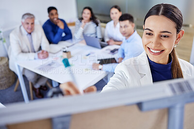 Buy stock photo Shot of a young businesswoman writing on a board during a meeting at work