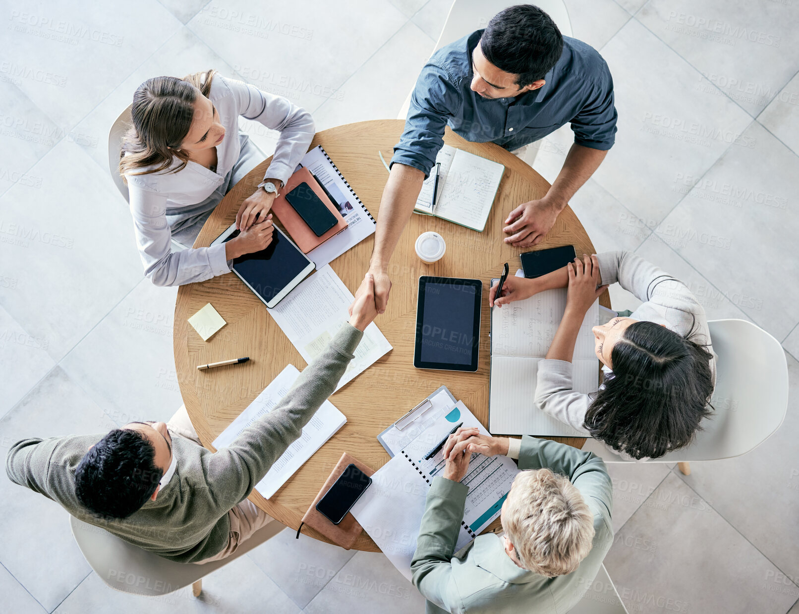 Buy stock photo Meeting, handshake and overhead with a business team sitting around a table in the office at work. Partnership, thank you and welcome with male colleagues shaking hands in agreement of a b2b deal