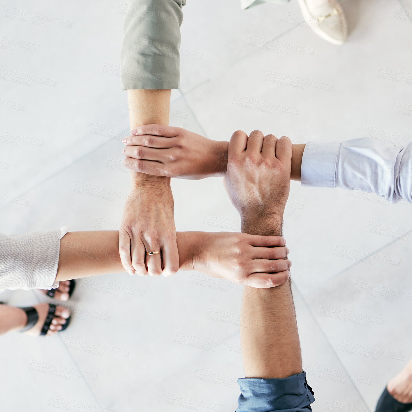 Buy stock photo Cropped shot of a group of businesspeople linking their arms in solidarity at work