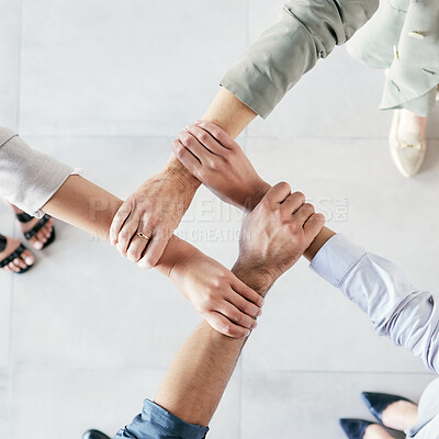 Buy stock photo Cropped shot of a group of businesspeople linking their arms in solidarity at work