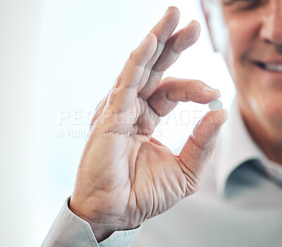 Buy stock photo Cropped shot of an unrecognizable businesspeople holding a pill while standing in his office
