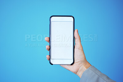 Buy stock photo Person, phone and hand with mockup screen for advertising or marketing against a blue studio background. Hands, mobile smartphone or app with mock up, copy space or display for brand advertisement