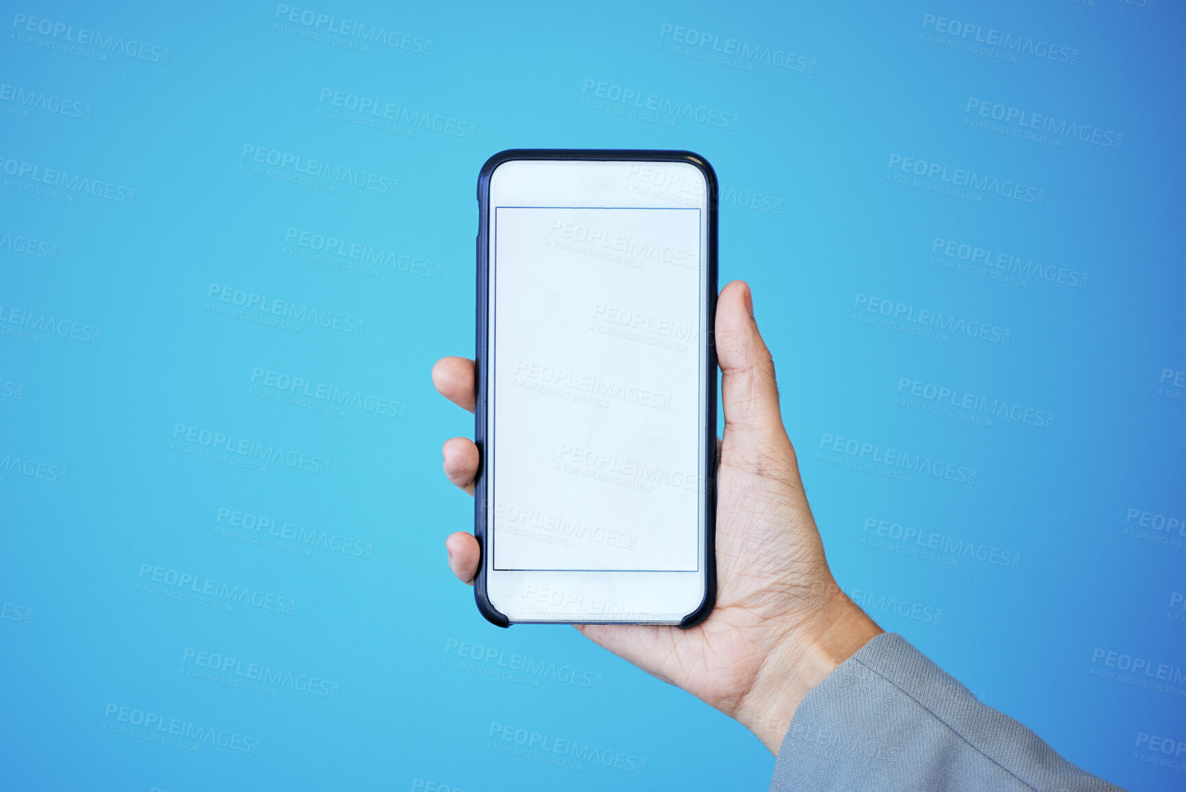 Buy stock photo Person, phone and hand with mockup screen for advertising or marketing against a blue studio background. Hands, mobile smartphone or app with mock up, copy space or display for brand advertisement