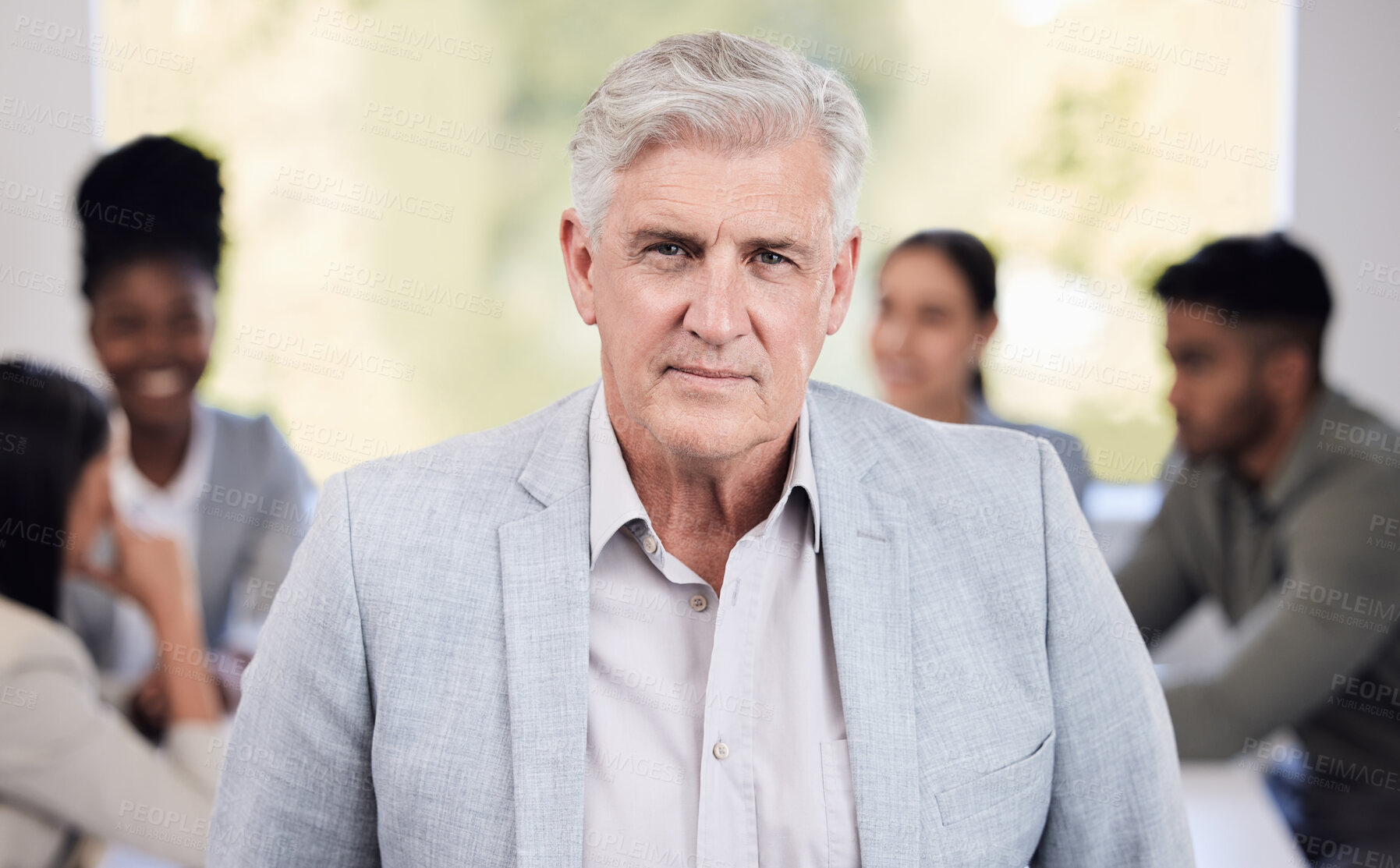 Buy stock photo Portrait of a senior businessman standing in an office with his colleagues in the background