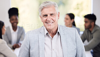 Buy stock photo Portrait of a senior businessman standing in an office with his colleagues in the background
