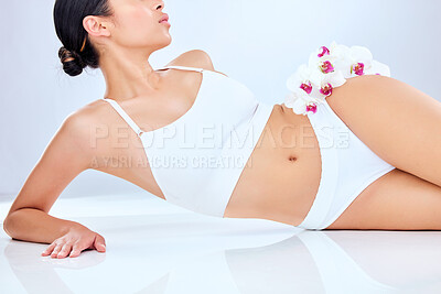 Buy stock photo Shot of a fit young woman lying against a grey studio background