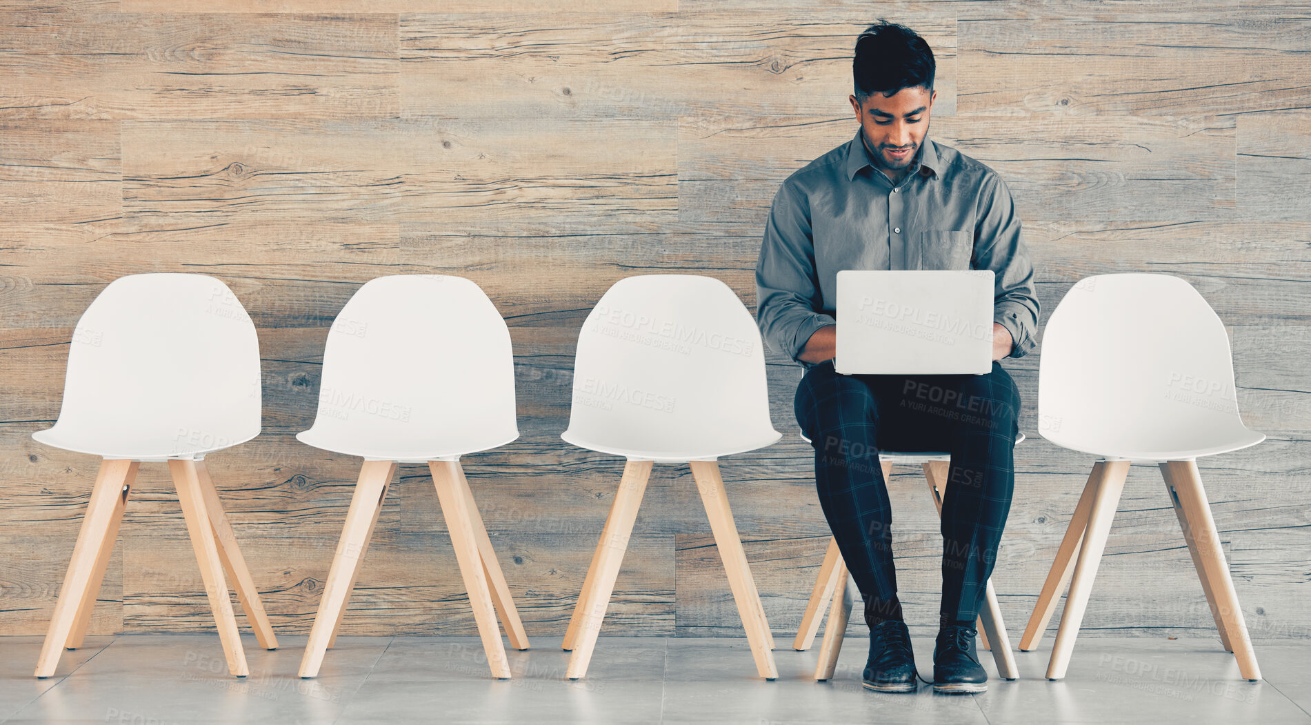 Buy stock photo Shot of a mature businessman using a laptop while waiting in line at an office