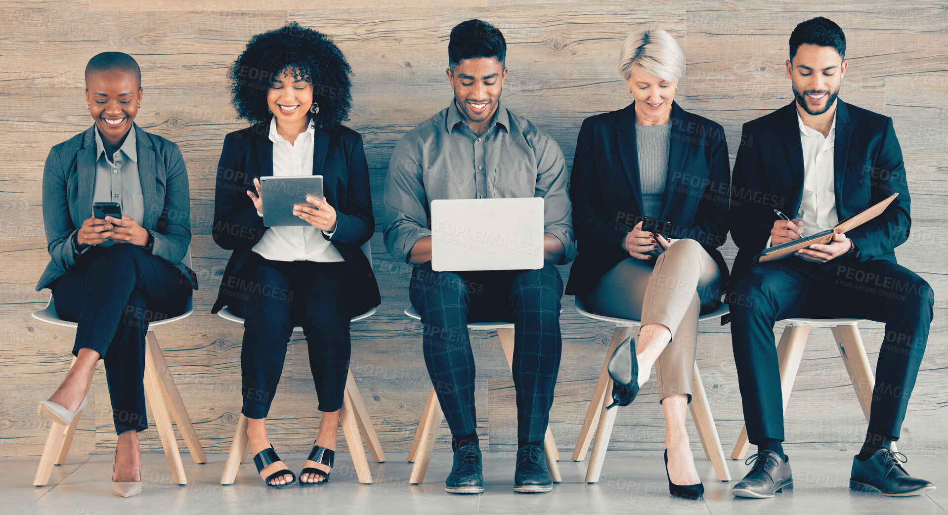 Buy stock photo Shot of a group of businesspeople using different forms of technology while waiting in line at an office