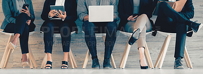 Buy stock photo Shot of a group of unrecognizable businesspeople using different forms of technology while waiting in line at an office