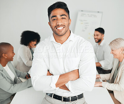 Buy stock photo Shot of a young businessman standing with his arms crossed at work