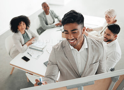Buy stock photo Shot of a young businessman writing on a whiteboard during a meeting at work