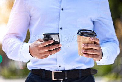 Buy stock photo Shot of an unrecognizable businessperson using a phone while drinking a coffee outside