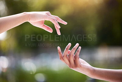 Buy stock photo Shot of two unrecognizable people reaching for each other outside
