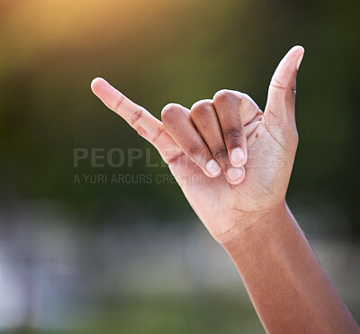 Buy stock photo Shot of an unrecognizable person showing a shaka sign with their hand outside