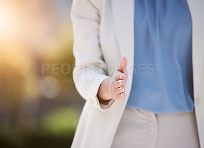 Buy stock photo Shot of an unrecognizable person extending their hand out for a handshake outside