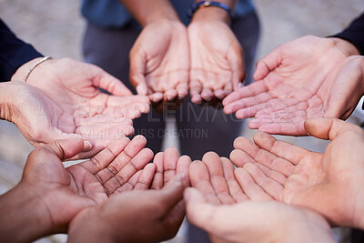Buy stock photo Shot of a group of people holding out their palms in a circle outside