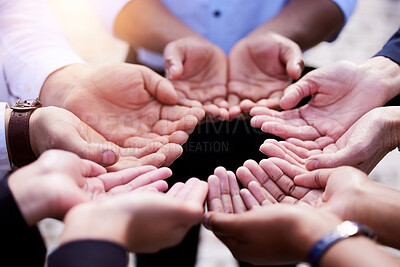 Buy stock photo Shot of a group of people holding out their palms in a circle outside