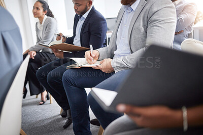 Buy stock photo Shot of a group of unrecognizable businesspeople writing in notebooks in a meeting at work