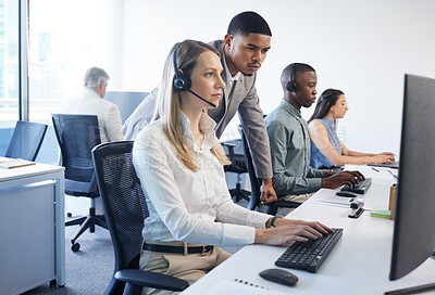 Buy stock photo Shot of a businessman and businesswoman using a headset and computer while working in a modern office