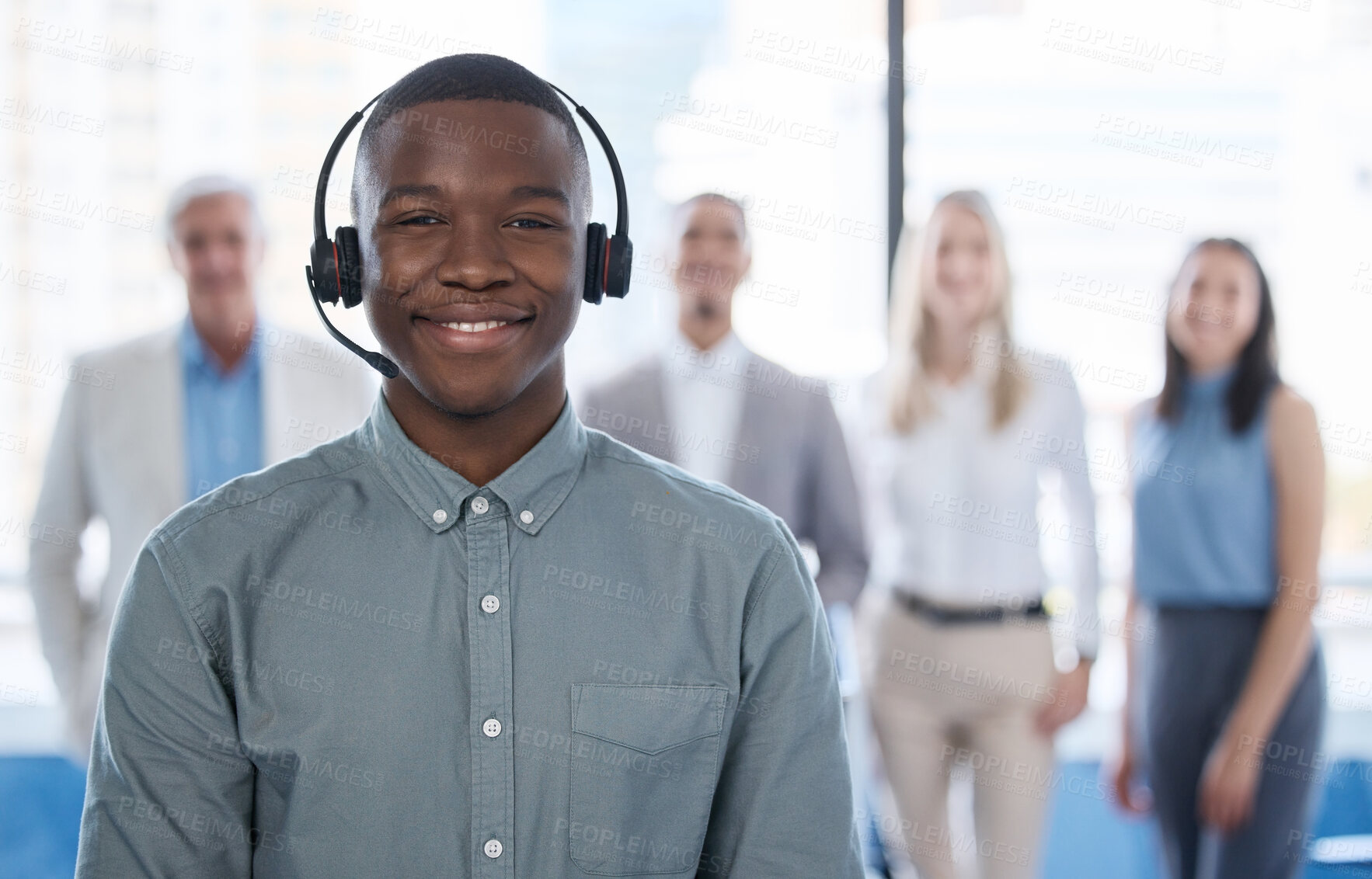 Buy stock photo Portrait of a young businessman using a headset in a modern office with his team in the background